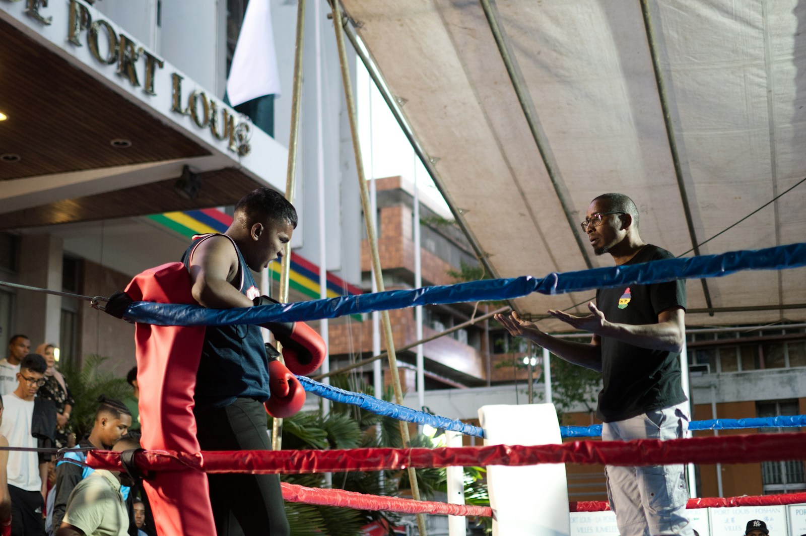A couple of men standing on top of a boxing ring